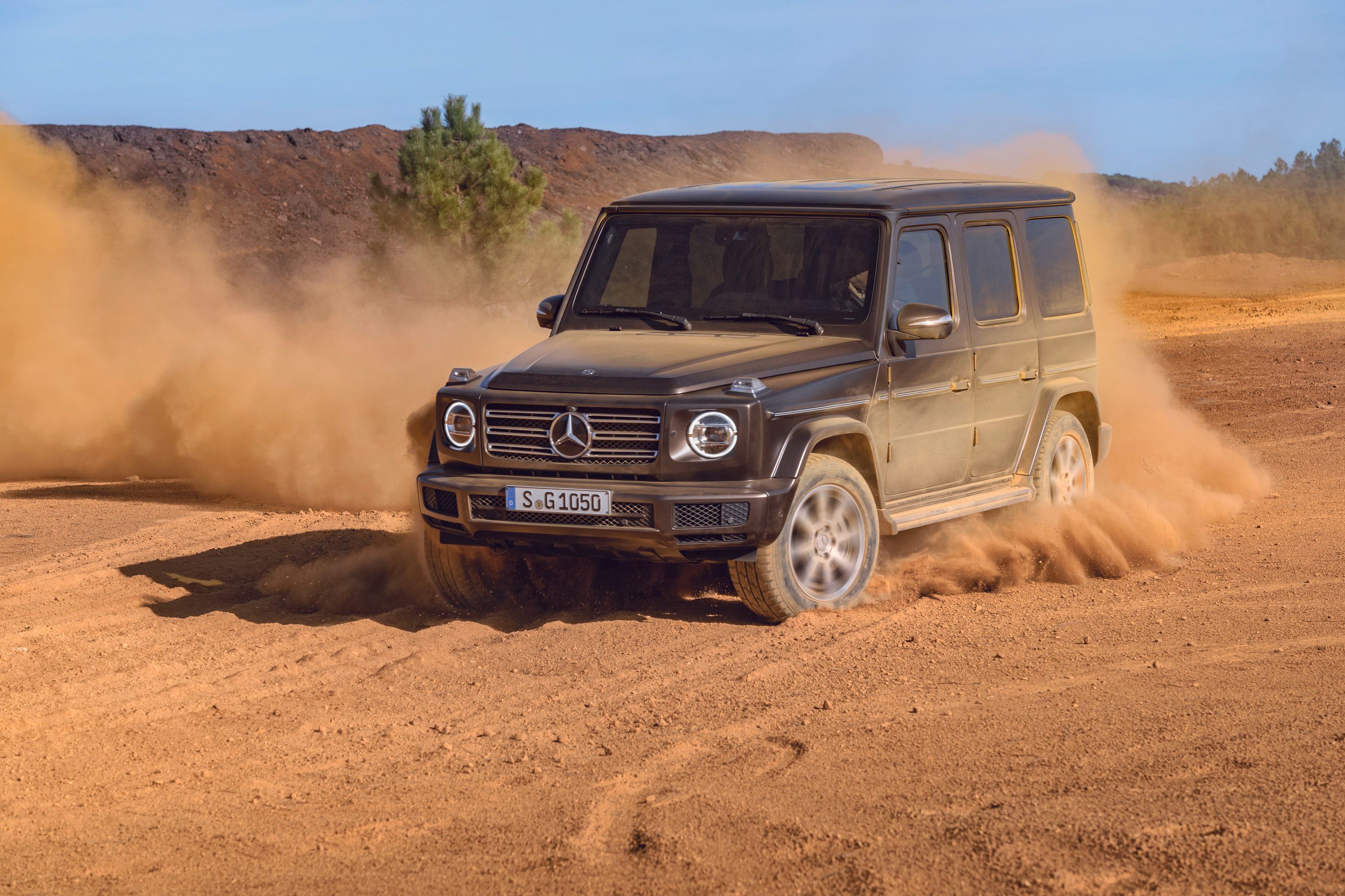Mercedes G-Wagon driving through a sandy desert 